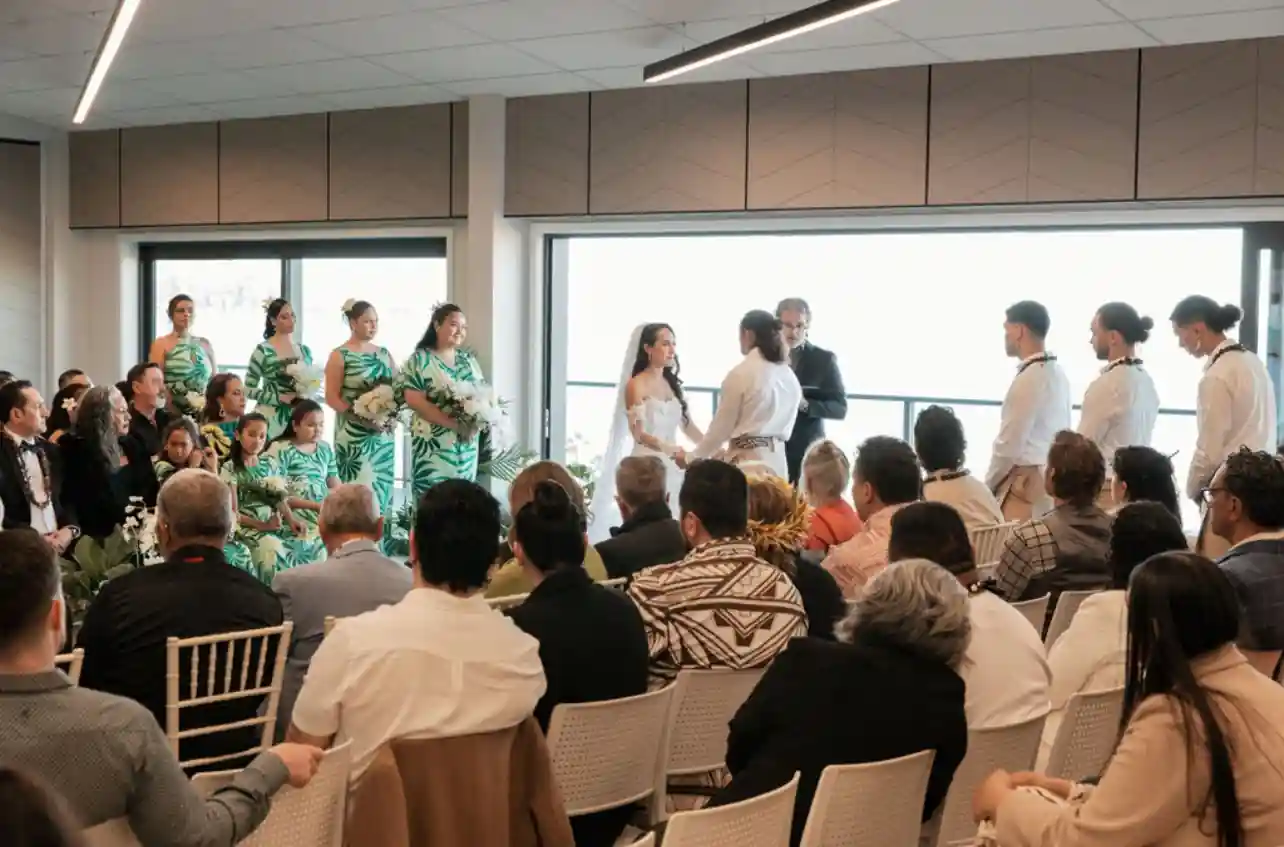Wedding ceremony vows beside ocean view windows at Gisborne beachfront venue
