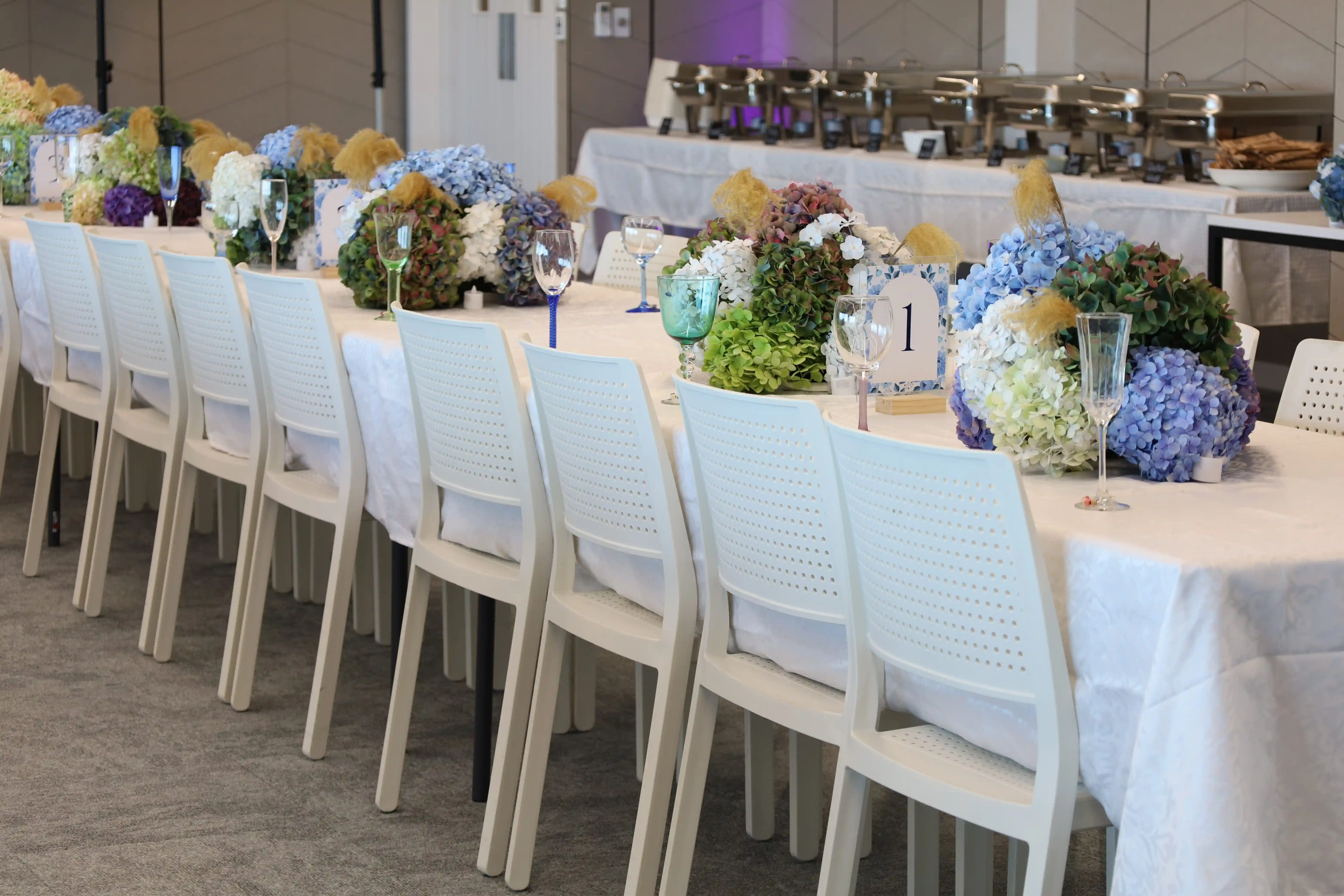 Hydrangea centrepiece with teal glass and table number at Gisborne wedding