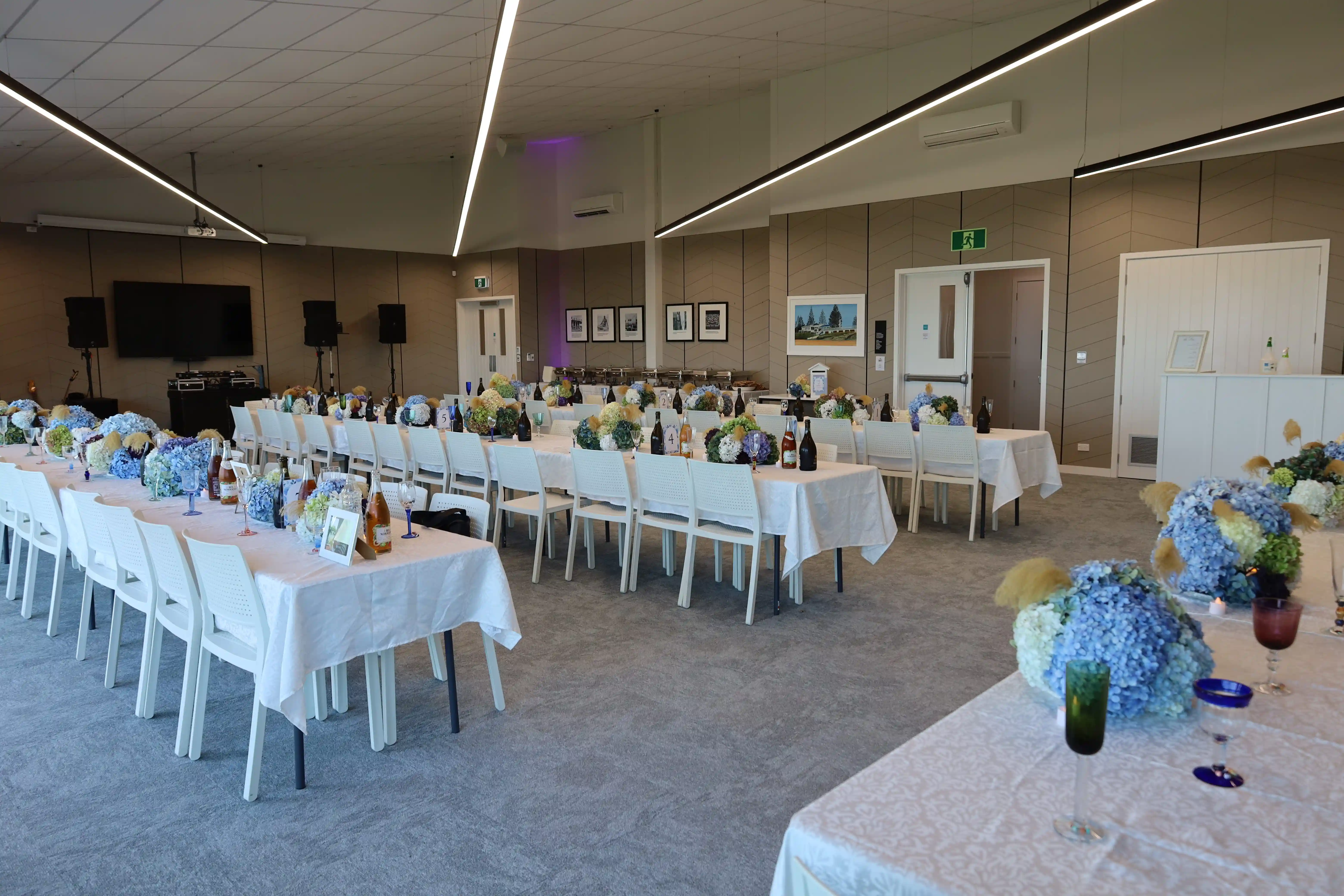 Wedding reception with pink tablecloths and blue hydrangea centrepieces