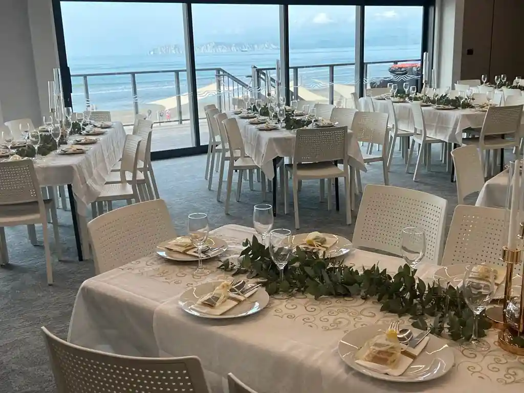 Round wedding reception tables with greenery runners overlooking the beach at Gisborne beachfront venue