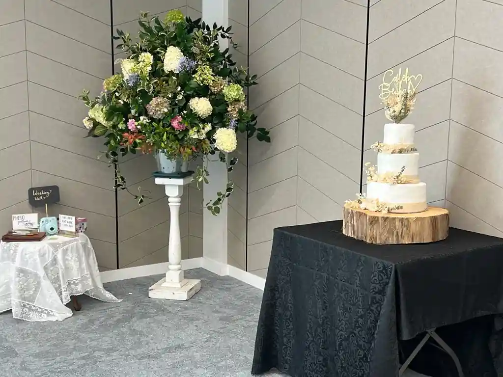 Wedding cake and floral arrangement at Gisborne beachfront venue