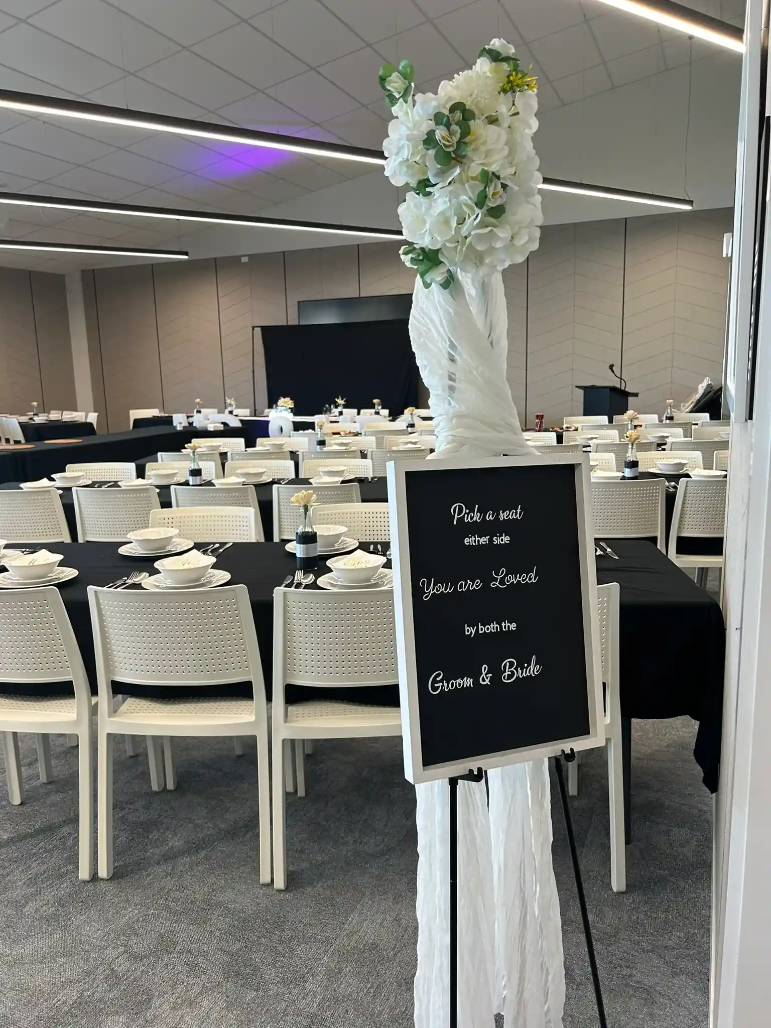 Pick a seat chalk sign on floral easel at Gisborne wedding venue entrance