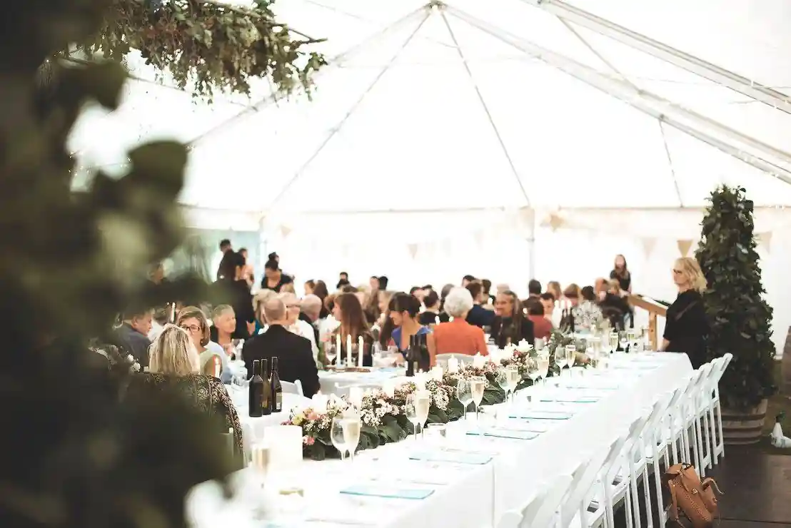 Gisborne arboretum wedding reception with bridal table floral garland runner and hanging greenery in marquee